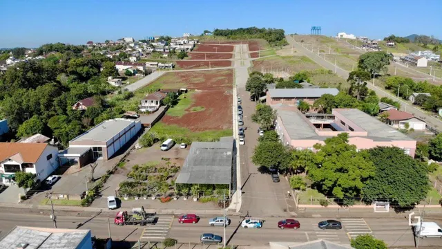 Vista aérea de uma propriedade com área verde e construções ao redor.