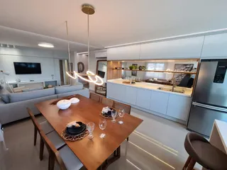 Foto de uma mesa de jantar de madeira em um ambiente interno.