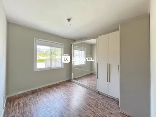 Esta é uma sala de estar com piso de madeira e armários brancos em um imóvel.