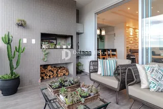 Interior de uma sala de estar com móveis de vime e plantas.