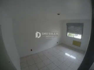 Vista interna de um cômodo com piso de cerâmica clara e parede branca.