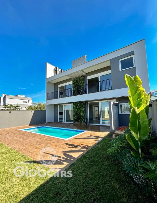 Fachada de uma casa com piscina e jardim em Lajeado.