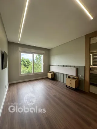 Sala de estar com piso de madeira e grande janela.