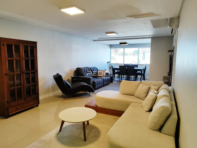 Sala de estar com sofá e móveis de madeira em um imóvel no Brasil.