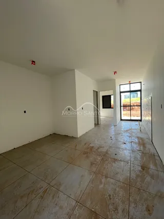 Vista interna de um cômodo com paredes brancas e piso de cerâmica.
