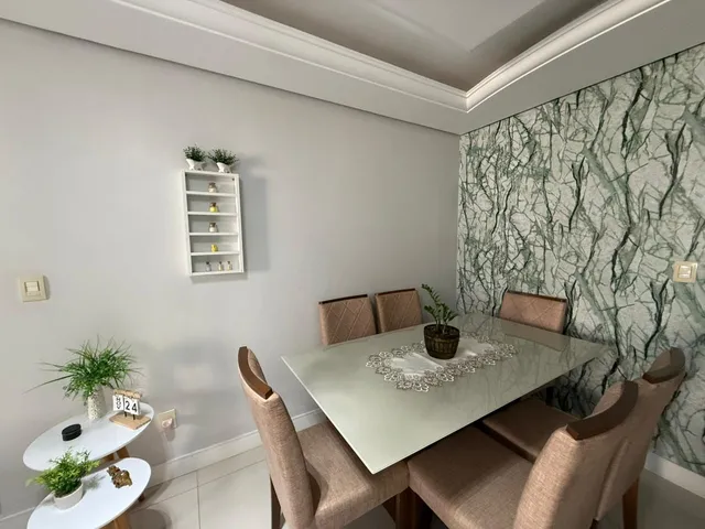Foto de uma sala de jantar com mesa e cadeiras.