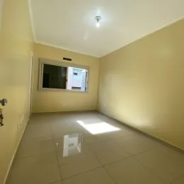 Foto de um ambiente interno com piso de cerâmica e paredes claras.