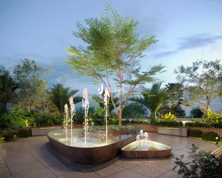 Vista de um jardim com fonte decorativa e vegetação exuberante.