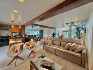 Sala de estar ampla com sofá e poltronas em ambiente moderno.