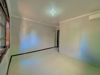 Vista de um cômodo amplo com paredes claras e iluminação de teto.