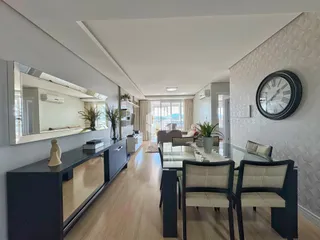 Imagem de uma sala de estar e jantar moderna com piso de madeira clara.