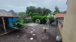 Vista externa de um pátio com vegetação e estrutura de madeira.