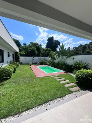 Foto de uma área externa com piscina e gramado verde em uma propriedade.
