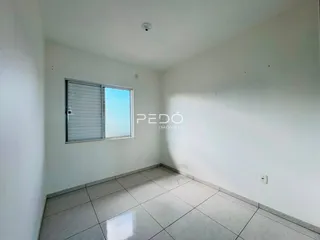 Ambiente interno de uma sala com piso de cerâmica e janela.