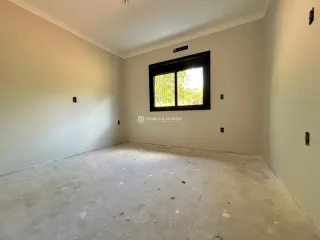 Foto de um cômodo vazio com piso de concreto e paredes brancas.