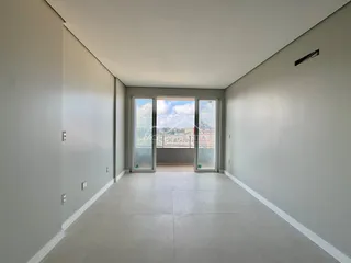 Foto de um corredor interno com portas de vidro que oferecem uma vista da paisagem urbana.