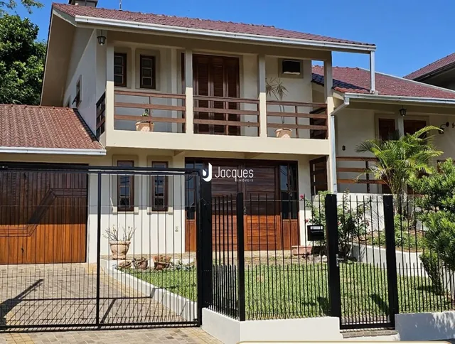 Fachada de uma casa em Lajeado, Brasil com cerca e jardim.