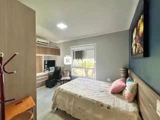 Quarto com cama e área de cozinha integrada em um apartamento.