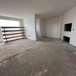 Foto de um ambiente interno com piso de concreto e paredes brancas.