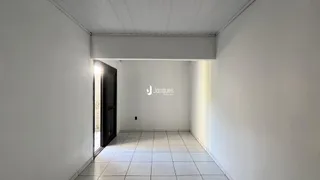 Hall de entrada com piso de cerâmica e paredes brancas.