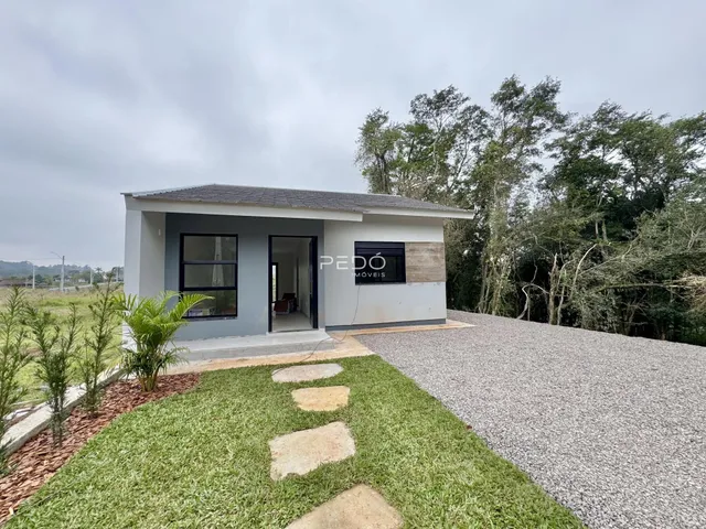 Fachada de uma casa em Lajeado, Brasil, com jardim e área pavimentada.