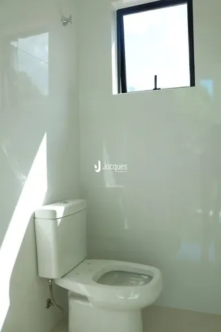 Foto de um vaso sanitário branco em um ambiente interno claro.