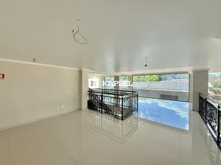 Sala ampla com piso claro e acesso a uma área externa.