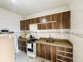 Foto de uma cozinha com armários de madeira e revestimento branco.