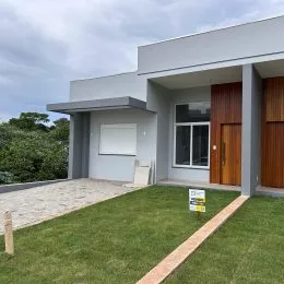 Fachada moderna de uma residência em Lajeado, Brasil, com gramado em primeiro plano.