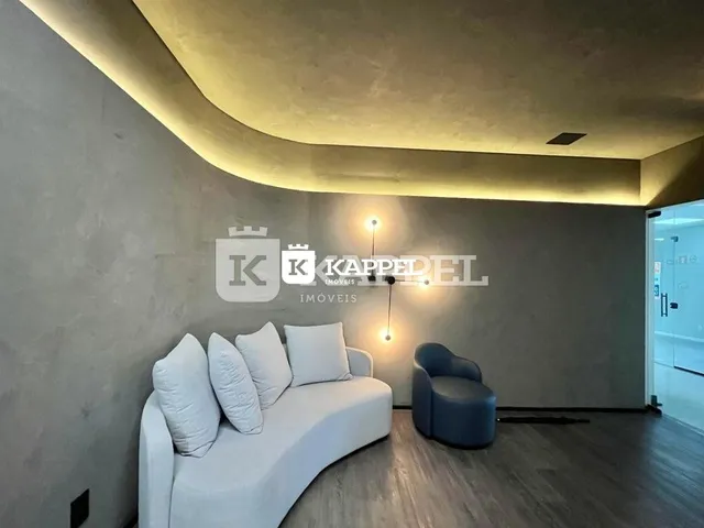 Sala de estar com sofá branco e piso de madeira.