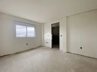 Interior de uma sala com paredes brancas e piso de concreto.