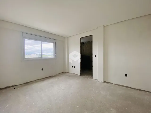Interior de uma sala com paredes brancas e piso de concreto.