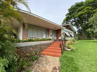 Fachada de uma residência com jardim e muro de contenção em Lajeado, Brasil.