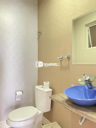 Foto de um banheiro mostrando um vaso sanitário branco e uma pia azul.