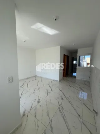Vista interna de um ambiente com piso de mármore claro.
