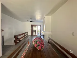 Hall de entrada com piso de madeira e corrimãos de madeira.