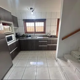 Foto de uma cozinha com armários e piso de cerâmica.