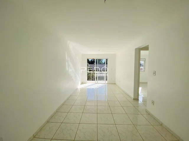 Corredor interno com piso de cerâmica clara e paredes brancas.