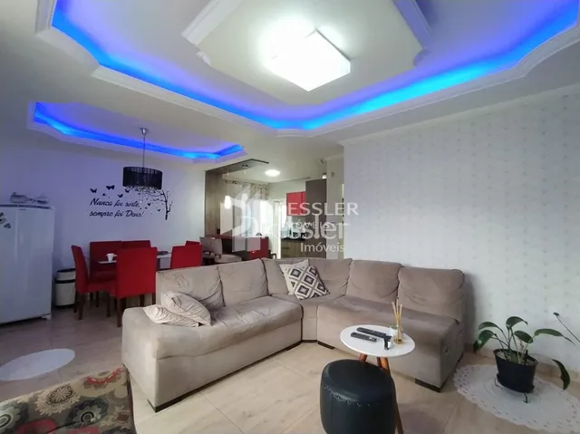 Sala de estar com sofá e iluminação azul no teto.