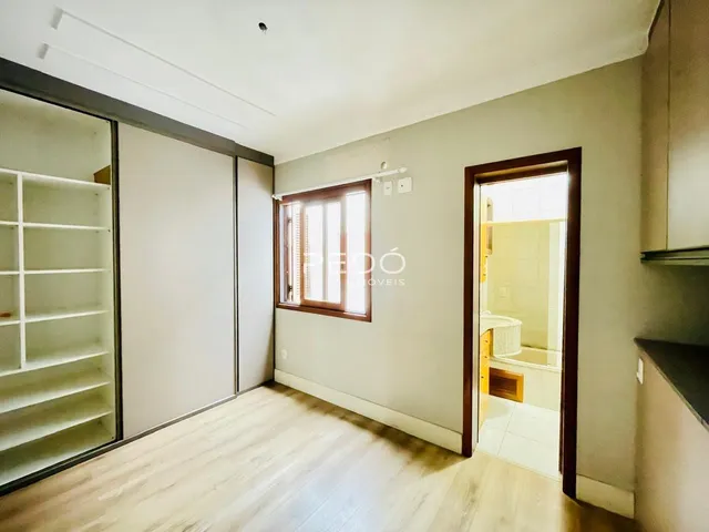 Ambiente interno de uma sala com piso de madeira clara e armário embutido.