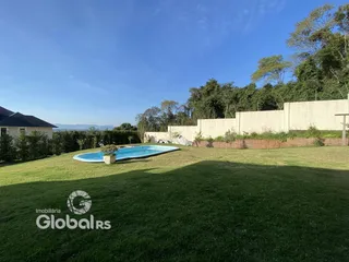 Vista externa de uma propriedade com piscina e jardim.
