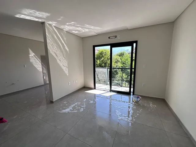 Foto de um ambiente interno com piso de porcelanato e porta de vidro que dá para o exterior.