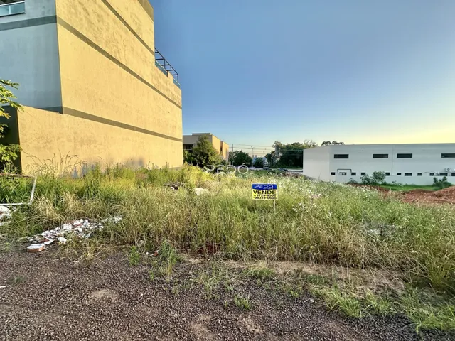 Fachada de um edifício com vegetação alta no primeiro plano.