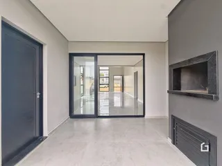 Corredor que leva a uma sala com portas de vidro.