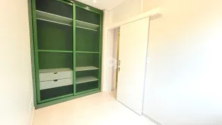 Um ambiente interno com um armário de metal verde e piso de cerâmica.
