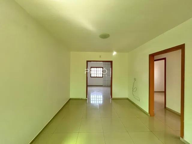 Hall de entrada com piso de cerâmica claro e paredes amarelas na residência.