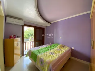 Quarto com cama e janela de acesso a uma varanda.