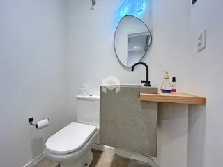 Foto de um banheiro moderno com vaso sanitário e bancada.