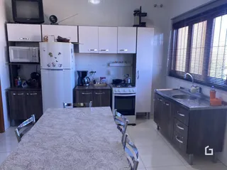 Cozinha com armários brancos e eletrodomésticos modernos.