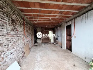 Hall de entrada com paredes de tijolo aparente e teto de madeira.